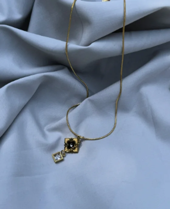 Fine chain necklace with a dark stone and square crystal pendant